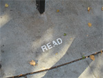 Message in the sidewalk under a canoe stand outside Pazzo’s Pizza, on Eastlake between Lynn and Louisa.